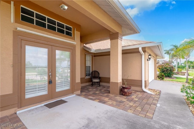 view of exterior entry with a patio area and french doors