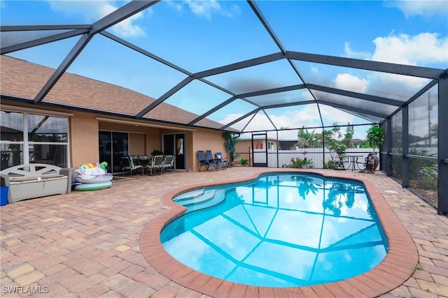 view of swimming pool with glass enclosure and a patio