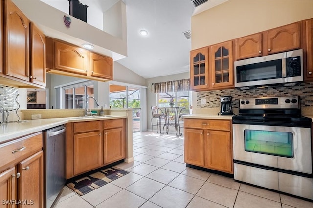 kitchen featuring light tile patterned flooring, appliances with stainless steel finishes, tasteful backsplash, and sink