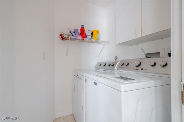 laundry room featuring light tile patterned floors, cabinets, and independent washer and dryer