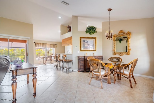 tiled dining space featuring vaulted ceiling and an inviting chandelier