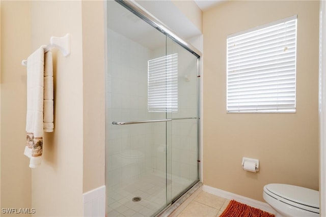 bathroom with tile patterned flooring, toilet, and walk in shower