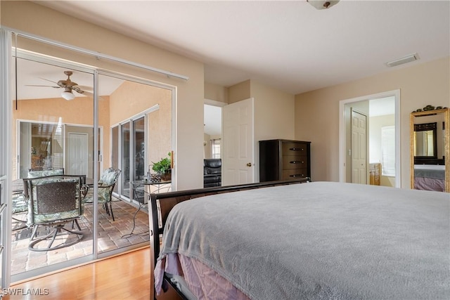 bedroom with access to exterior, hardwood / wood-style floors, and ceiling fan