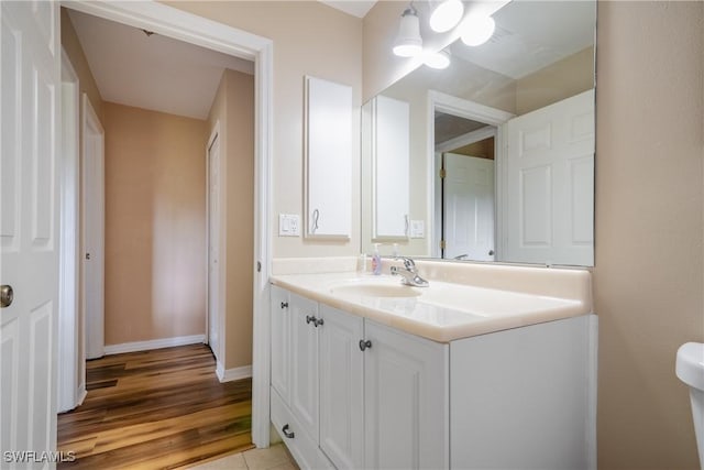 bathroom featuring wood-type flooring, vanity, and toilet