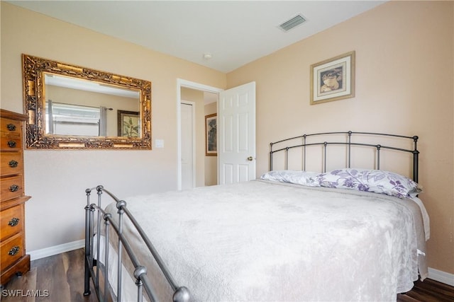 bedroom with dark hardwood / wood-style flooring