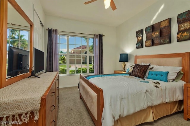 bedroom featuring multiple windows, ceiling fan, and light colored carpet