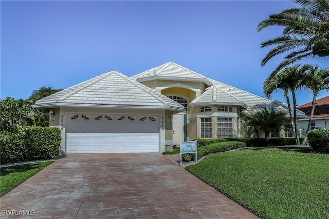 view of front of property featuring a garage and a front lawn