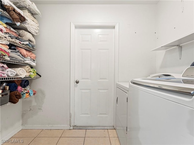 washroom featuring washing machine and clothes dryer and light tile patterned flooring