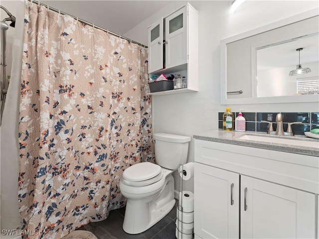 bathroom with tile patterned flooring, vanity, toilet, and walk in shower