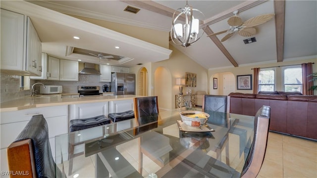 tiled dining space with ceiling fan with notable chandelier, beam ceiling, crown molding, and sink