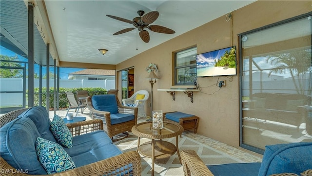 sunroom / solarium featuring plenty of natural light and ceiling fan