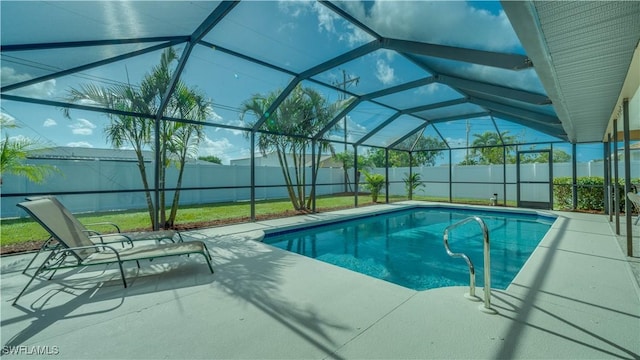 view of pool with glass enclosure and a patio area