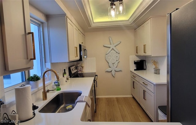 kitchen with white cabinets, appliances with stainless steel finishes, plenty of natural light, and sink