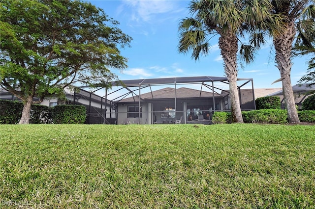 back of property featuring a lanai and a lawn