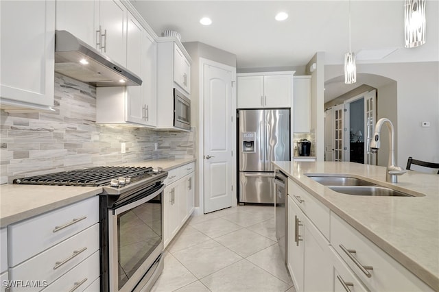 kitchen with sink, white cabinetry, stainless steel appliances, and hanging light fixtures