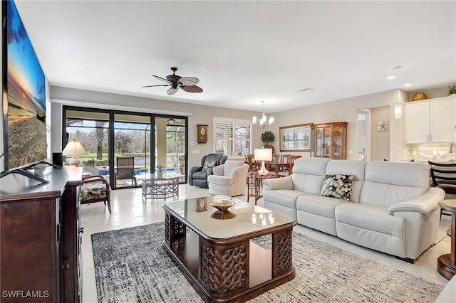 living room with light tile patterned floors and ceiling fan with notable chandelier