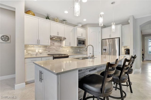 kitchen with white cabinetry, a center island with sink, stainless steel appliances, and sink