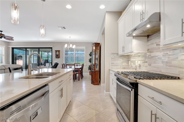 kitchen with sink, decorative light fixtures, white cabinets, ceiling fan with notable chandelier, and appliances with stainless steel finishes