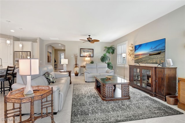 living room featuring light tile patterned floors and ceiling fan