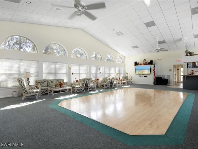 interior space featuring carpet, ceiling fan, and a towering ceiling