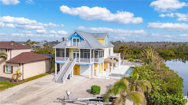 view of front of property with a balcony, a water view, and a garage