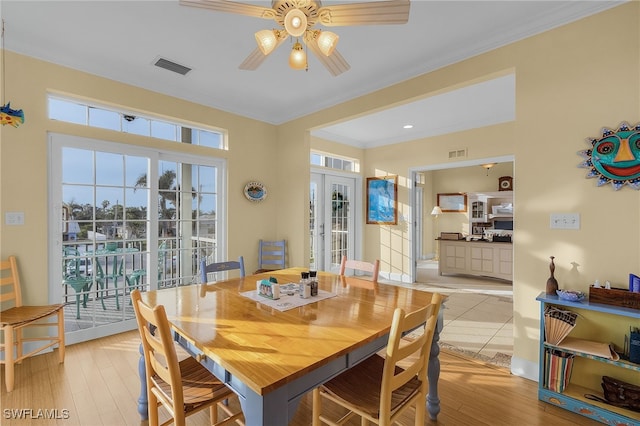 dining space with ceiling fan, french doors, light hardwood / wood-style floors, and ornamental molding