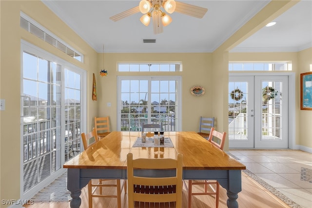 tiled dining space featuring french doors, ceiling fan, and crown molding