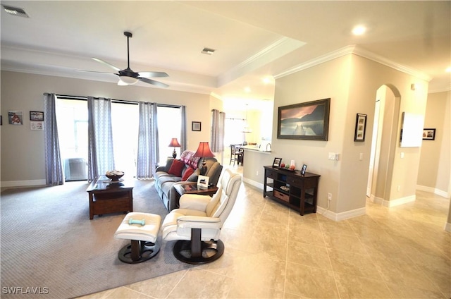 living room with a tray ceiling, crown molding, ceiling fan, and light tile patterned floors