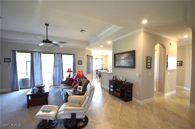 tiled living room with ceiling fan and ornamental molding