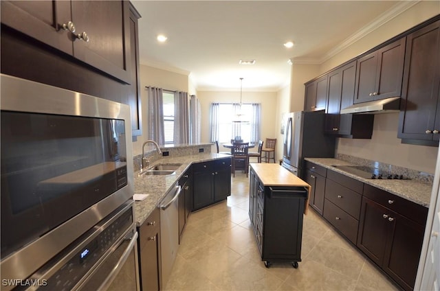 kitchen featuring hanging light fixtures, crown molding, sink, appliances with stainless steel finishes, and a kitchen island