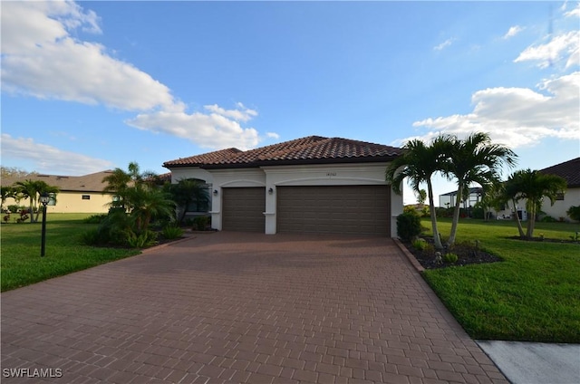 mediterranean / spanish house with a garage and a front lawn