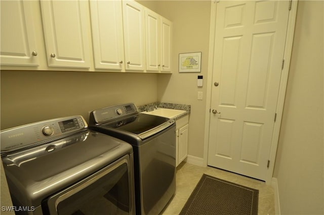 clothes washing area featuring cabinets, light tile patterned flooring, washing machine and dryer, and sink