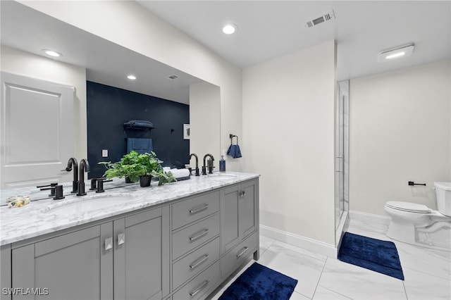 bathroom featuring toilet, a shower with door, and vanity