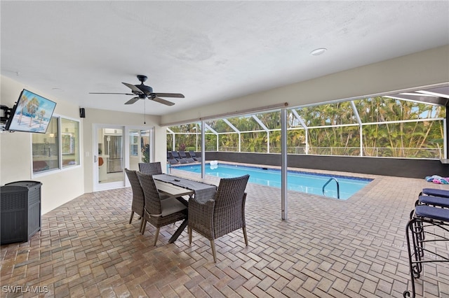 view of pool with a lanai, ceiling fan, and a patio