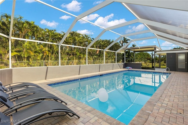 view of swimming pool featuring glass enclosure and a patio