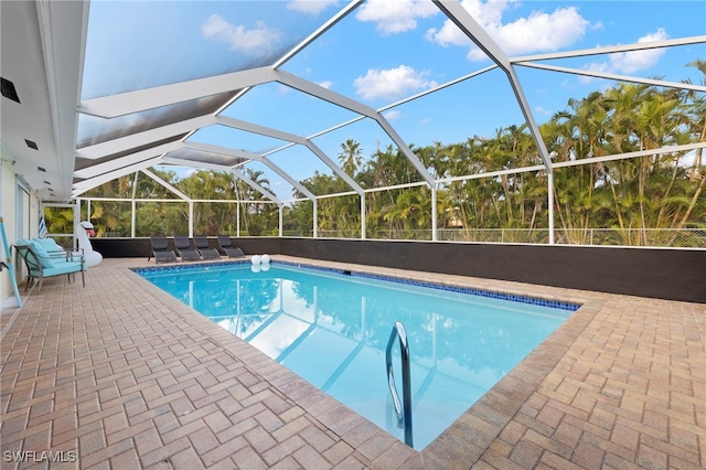 view of swimming pool with glass enclosure and a patio area