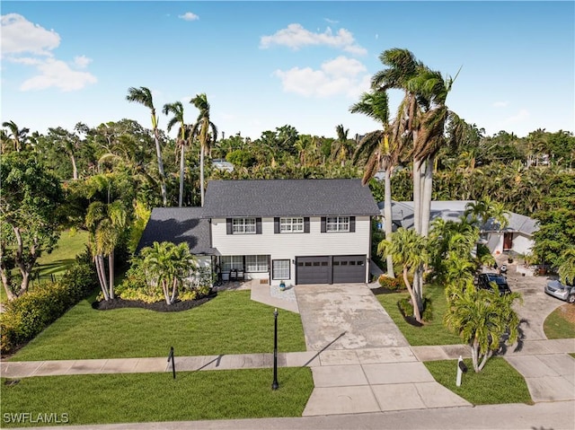 view of front of home featuring an attached garage, driveway, and a front yard