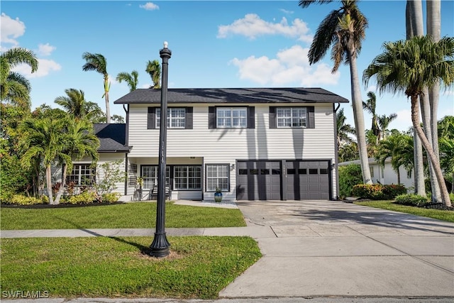 view of front of home with a garage, concrete driveway, and a front yard