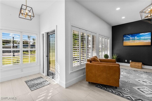 living area featuring a chandelier, recessed lighting, and baseboards