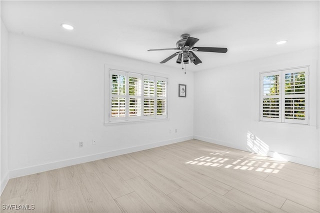 unfurnished room featuring light wood-style floors, a wealth of natural light, baseboards, and recessed lighting