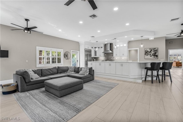 living room with visible vents, light wood finished floors, a ceiling fan, and recessed lighting