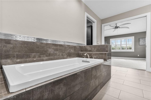 bathroom featuring a garden tub, ceiling fan, tile patterned flooring, and baseboards