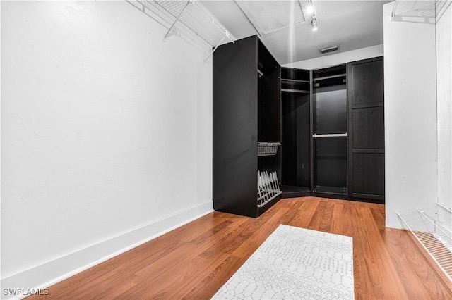 walk in closet featuring visible vents and wood finished floors