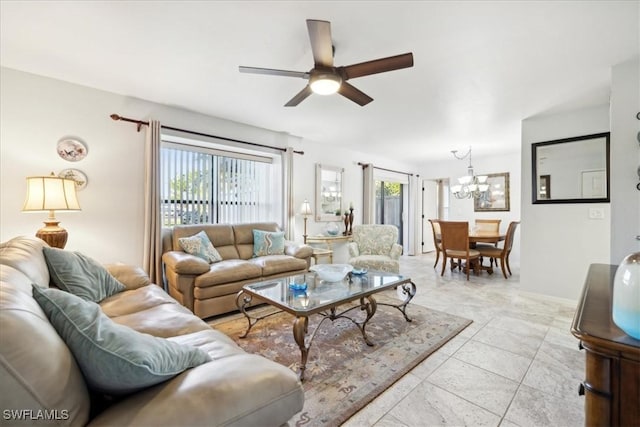 living room featuring ceiling fan with notable chandelier and plenty of natural light