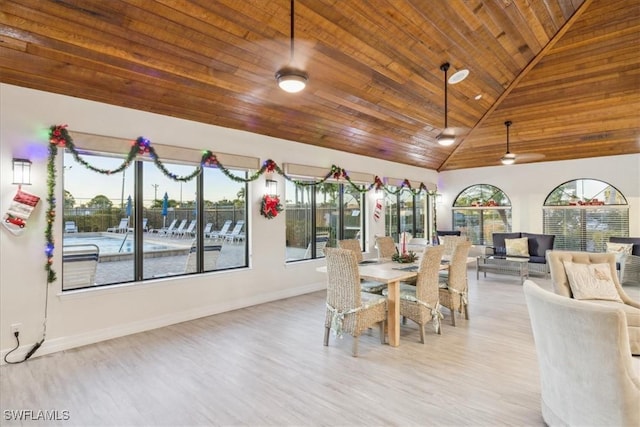 dining space with light hardwood / wood-style floors, high vaulted ceiling, and wooden ceiling