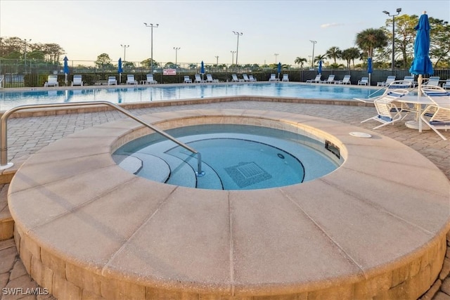 view of pool with a hot tub