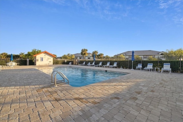 view of swimming pool featuring an outbuilding and a patio