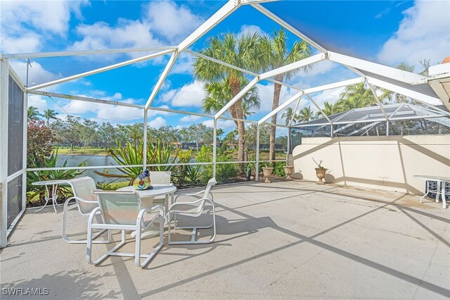 view of patio / terrace with a water view and glass enclosure