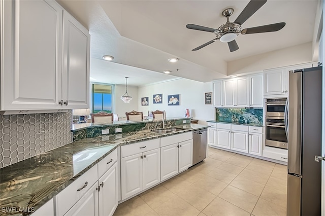 kitchen with sink, white cabinetry, stainless steel appliances, and dark stone counters