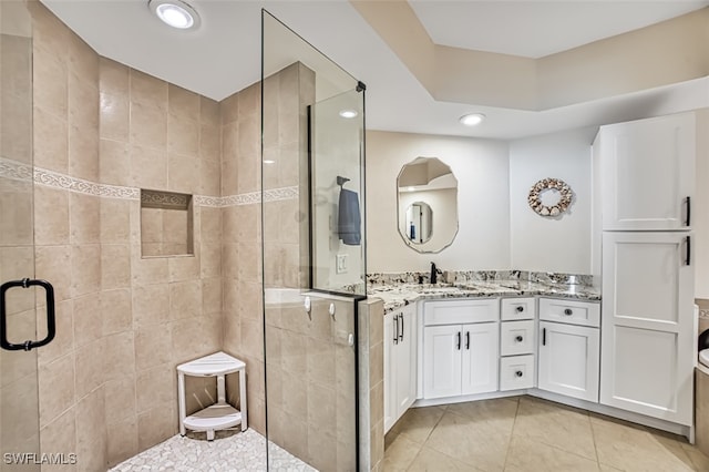 bathroom with tile patterned floors, vanity, and an enclosed shower